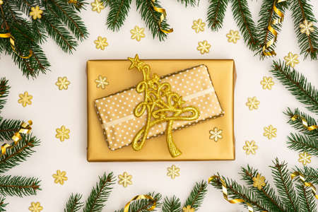 Festive background with gold decoration , green spruce branches and shiny golden serpentine confetti, gift boxes and glittering snowflakes , flat lay, top viewの写真素材