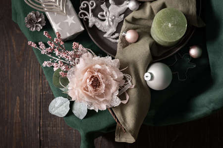 Christmas composition in sail champagne ,green and gray shades, christmas balls and candle, cookie cutters and decorative flower on a green tablecloth, top view, copy spaceの写真素材