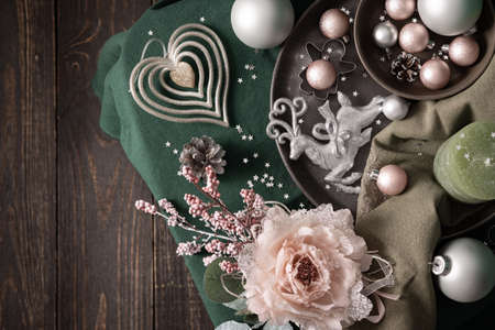 Christmas composition in sail champagne ,green and gray shades, christmas balls and candle, cookie cutters and decorative flower on a green tablecloth, top view, copy spaceの写真素材