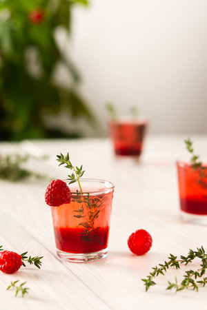 Raspberry alcoholic shots, shot glasses with colored liquor on a white backgroundの写真素材
