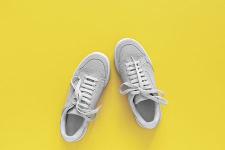 Gray nubuck sneakers isolated on a yellow background, seasonal shoes for walking and sports, top...