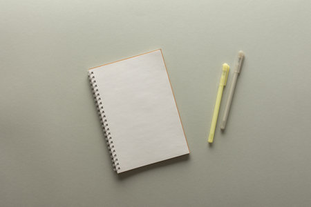 Open spiral notepad on gray background , notebook and pen lie on textural paper, flat lay concept in trendy colors of the year yellow and grayの写真素材