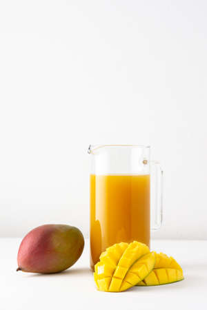 Mango juice in a glass jug on whiteの写真素材