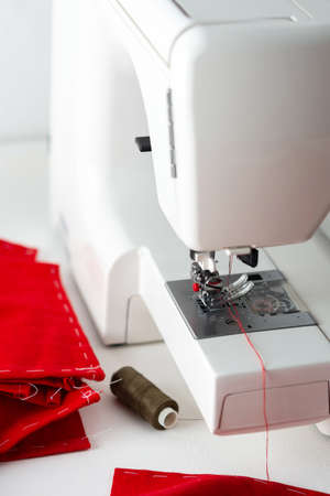 Modern sewing machine with red fabric, cutting and sewing at home, home leisure and hobbyの写真素材