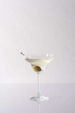 Vermouth in a cocktail glass with olives on a gray background, slightly alcoholic drinkの写真素材