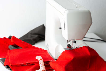 Modern sewing machine with red and gray fabric, measuring tape , cutting and sewing at home, home leisure and hobbyの写真素材