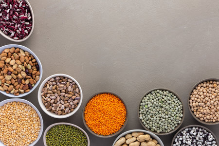 Different types of legumes in bowls, green and yellow peas, chickpeas and peanuts, colored beans and lentils, mung beans and beans, top viewの写真素材