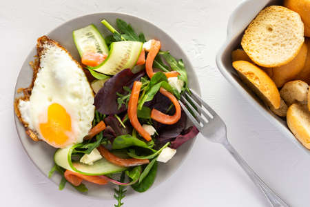 Fresh organic mesclun mix salad with cucumber, mozzarella and salmon, scrambled eggs and dry bunsの写真素材