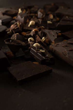Dark chocolate with almonds and hazelnuts on brown backgroundの写真素材