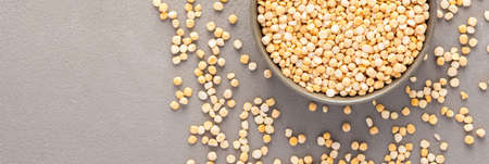 Legumes in bowl and scattered in the background, yellow peas in a plate banner, top view, copy spaceの写真素材