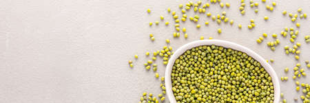 Legumes in bowl and scattered in the background, mung beans in a plate banner, top view, copy spaceの写真素材