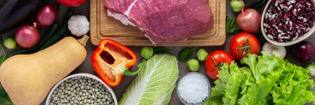 Fresh farm organic vegetables banner, healthy food concept, vegetables and mushrooms, superfoods and beans around the board with a large fresh piece of beef fillet, top viewの写真素材
