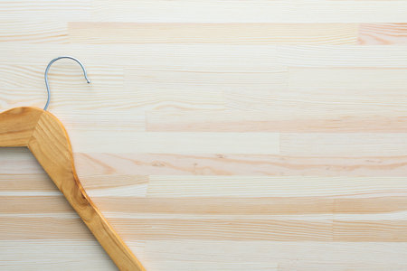 Empty clothes hanger isolated on wooden backgroundの写真素材