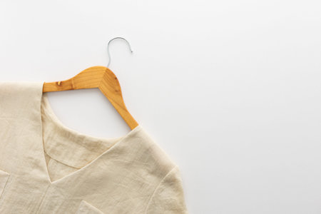 Wooden hanger with linen dress isolated on a white background