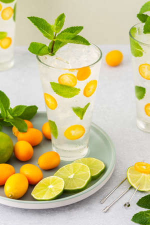 Cold refreshing drink with kumquats and mint, water with citrus fruits and iceの写真素材