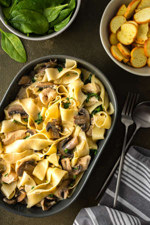 Fettuccini pasta with mushrooms and chicken breast and basil in a creamy sauce, top viewの写真素材