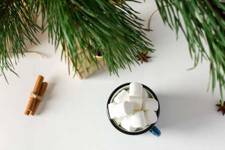 Festive christmas table top view, pine branches and mug with marshmallows, gift boxes and dried citrus fruits, cinnamon with star aniseの写真素材