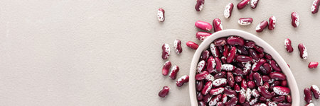 Legumes in bowl and scattered in the background, red beans in a plate banner, top view, copy spaceの写真素材