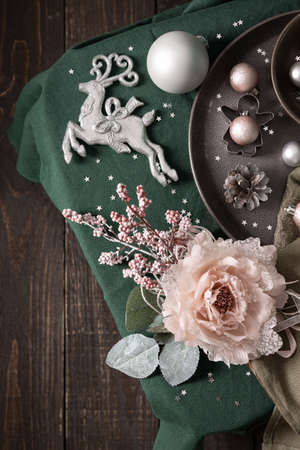 Christmas composition in sail champagne ,green and gray shades, christmas balls and candle, cookie cutters and decorative flower on a green tablecloth, top view, copy spaceの写真素材