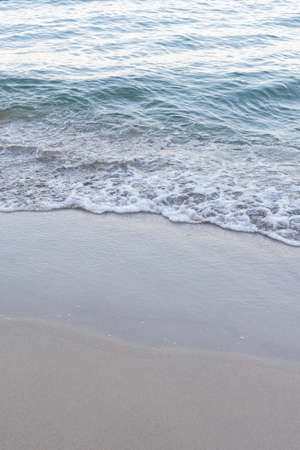 Sea coast in summer, the wave rolls over the sandy shoreの写真素材
