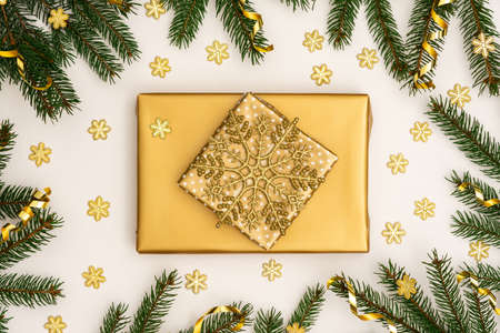 Festive background with gold decoration , green spruce branches and shiny golden serpentine confetti, golden gift boxes with bow ,glittering snowflakes , flat lay, top viewの写真素材
