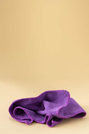 Purple microfiber cloth for washing on a neutral beige background, cleaning conceptの写真素材
