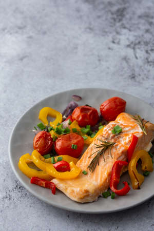 Baked red fish fillet Arctic char on a plate with vegetables close up, delicious hearty healthy dinnerの写真素材