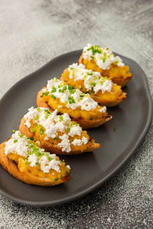 Fried croutons with mashed pumpkin and ricotta cheese, sprinkled with green onions, seasonal autumn foodの写真素材