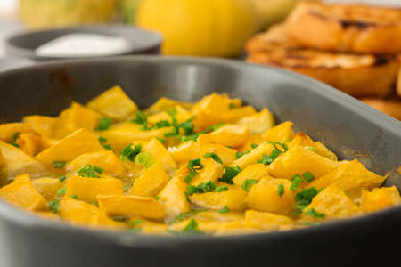 Stewed pumpkin slices in an oval dish close up with ricotta cheese and toasted croutons, top view, seasonal autumn foodの写真素材