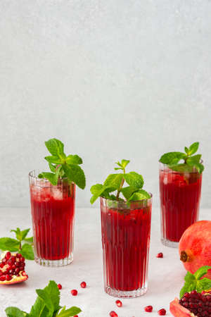 Refreshing pomegranate juice in glasses with mint and ice, cold drinkの写真素材