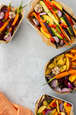 Fresh chopped vegetables cooked for roasting in the oven in various ceramic dishes, top viewの写真素材