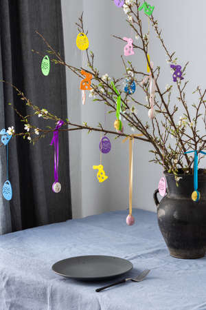 Blooming cherry branches decorated with colorful ribbons with easter eggs, Happy Easter, table settingの写真素材
