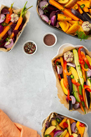 Fresh chopped vegetables cooked for roasting in the oven in various ceramic dishes, top viewの写真素材
