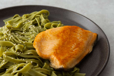 Green pasta tagliatelle with red fish Arctic char, delicious healthy lunchの写真素材