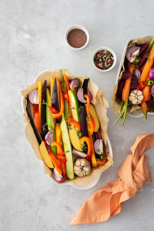 Fresh chopped vegetables cooked for roasting in the oven in various ceramic dishes, top viewの写真素材