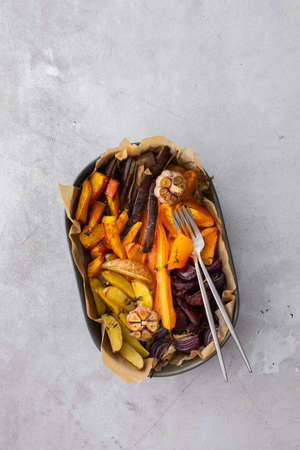 Fresh stewed vegetables baked in the oven, top view of vegetables in various ceramic dishesの写真素材