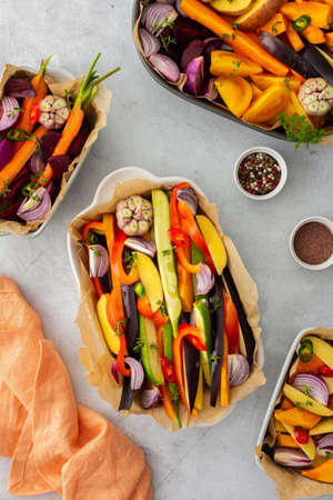 Fresh chopped vegetables cooked for roasting in the oven in various ceramic dishes, top viewの写真素材