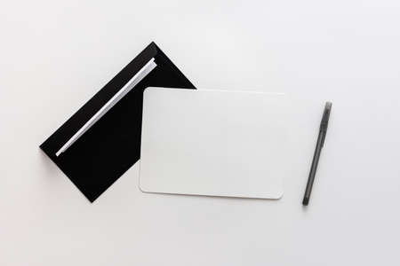 Black envelope with blank paper and pen, greeting card or invitation mockup, top view, copy spaceの写真素材