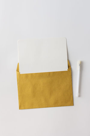 Craft envelope with blank paper and pen, greeting card or invitation mockup, top view, copy space