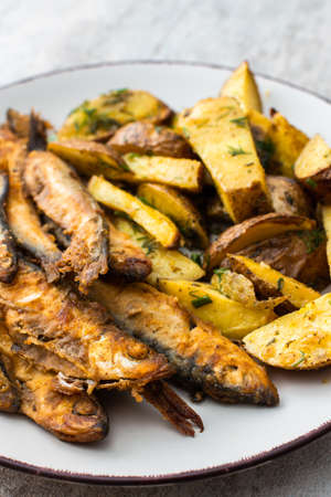 Hearty dinner, baked potatoes with dill and flour-fried capelin close upの写真素材