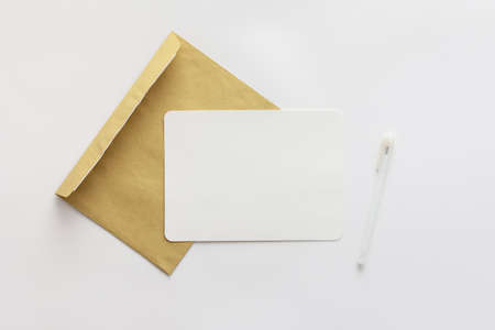 Craft envelope with blank paper and pen, greeting card or invitation mockup, top view, copy spaceの写真素材