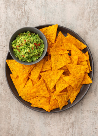 Mexican corn chips nachos with avocado red pepper sauce, top view, copy spaceの写真素材