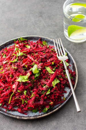 Vegetarian salad with couscous and grated beets, parsley and dill and green onions, light healthy tasty saladの写真素材