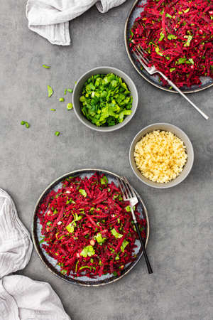 Vegetarian salad with couscous and grated beets, parsley and dill and green onions, light healthy tasty saladの写真素材