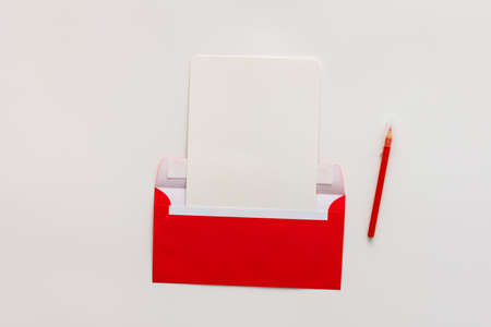 Red envelope with blank paper and pen, greeting card or invitation mockup, top view, copy spaceの写真素材