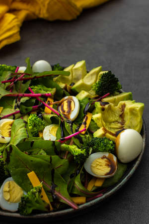 Beetroot leaves Chard with with quail eggs, avocado and Cheddar cheese, healthy fresh salad with balsamic vinegarの写真素材