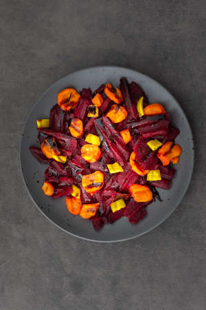 Warm salad with boiled carrots and beetroot and green peppers, top viewの写真素材