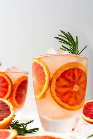 Fruity refreshing drink with blood oranges and ice and rosemary, delicious sweet juiceの写真素材