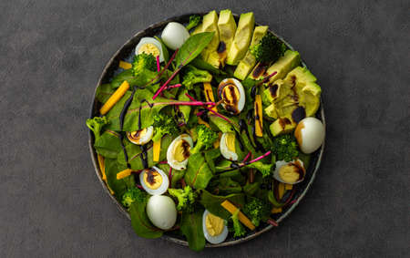 Beetroot leaves Chard with with quail eggs, avocado and Cheddar cheese, healthy fresh salad with balsamic vinegar, top viewの写真素材