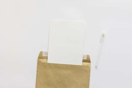Craft envelope with blank paper and pen, greeting card or invitation mockup, top view, copy spaceの写真素材